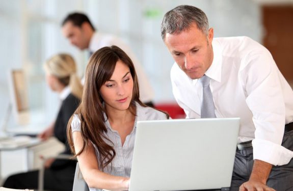 woman showing her boss something on laptop
